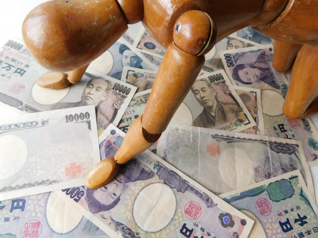 お金の上でうなだれる。筑紫野市で借金返済の無料相談ができます
